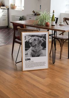 a dog is sitting on the floor next to a table with a sign that says luna