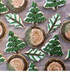 cookies decorated with green and white icing are arranged on a wooden surface, as well as small trees