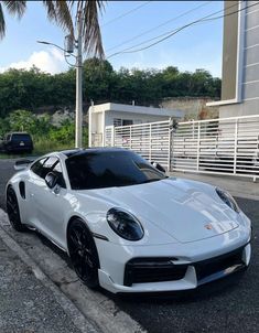 a white sports car parked in front of a building