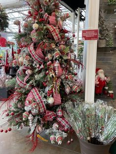 a christmas tree is decorated with red, white and green plaid ribbon for the holiday season