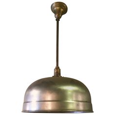 an industrial style pendant light fixture with a metal dome on the bottom and a brass finish