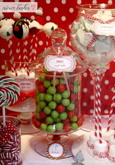 there are many candies in the glass jar on the table with candy canes