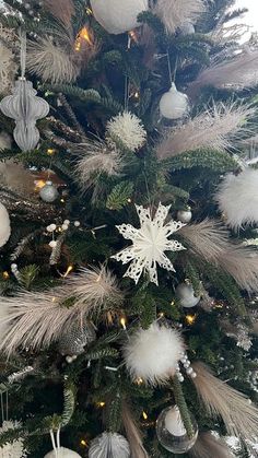 a decorated christmas tree with white and silver ornaments