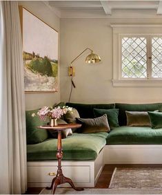 a living room with green couches and white walls