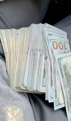 a pile of money sitting on top of a car seat