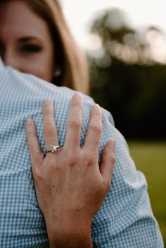 a woman is holding her engagement ring on her finger