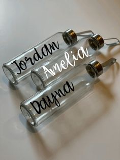 three empty glass bottles with writing on them