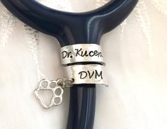 a pair of scissors with two charms attached to it's handles that read, dr kuceon dvm