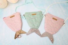 three fish shaped purses are hanging on a string