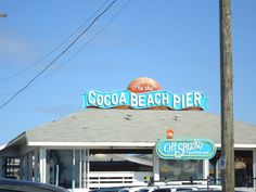 the cocoa beach pier restaurant is located on the corner of an intersection with cars parked in front