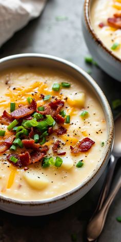 two bowls of potato soup with bacon and green onions