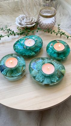 four tea light candles sitting on top of a wooden table