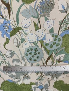 a ruler is shown next to a floral print wallpaper with blue and white flowers