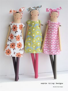 three dolls are standing next to each other in different dresses and hair bows on their heads