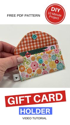 a hand holding an orange and white purse with the words gift card holder on it