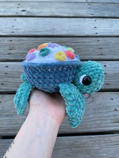 a hand holding a small knitted hat with an octopus on it's head