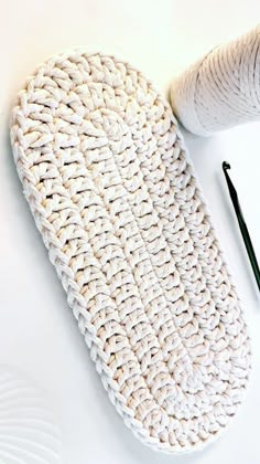 a pair of scissors, yarn and knitting needles on a white surface with a crochet pattern