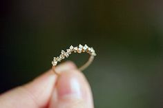 a person is holding a tiny diamond ring