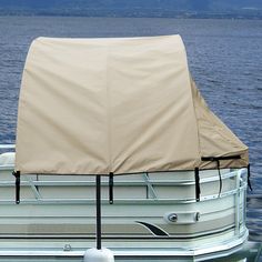 a boat that is sitting in the water with a cover on it's back