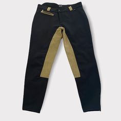 a pair of black and gold pants with zippers on the side, sitting against a white background