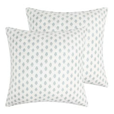 two blue and white pillows on a white background