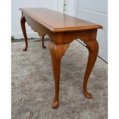 a wooden table sitting on top of a carpeted floor next to a white door