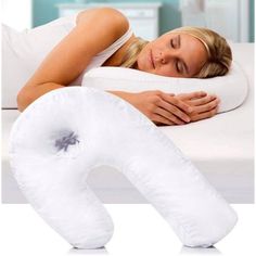 a woman laying on top of a bed next to an inflatable neck pillow