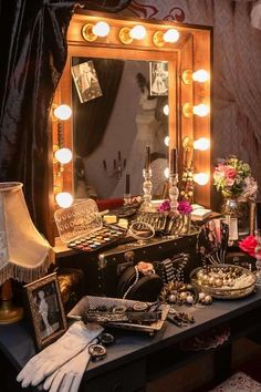 a vanity with makeup and accessories on it in front of a mirror that is lit up