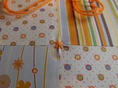 an orange string is tied to the fabric on top of some different patterns and colors