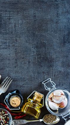 an assortment of food is displayed on a table with utensils and spoons