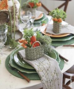 a table set with plates, napkins and flowers in a basket on top of them