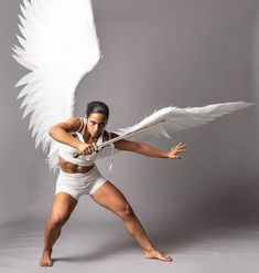 a woman with white wings is posing for a photo