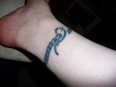 a person with a tattoo on their foot that has a blue ribbon and an arrow