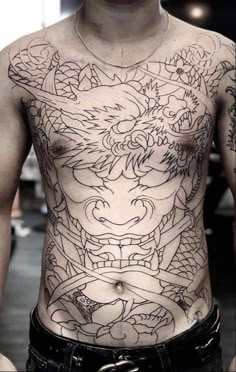 a man with a dragon tattoo on his chest is standing in front of the camera