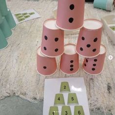 several pink cups with black dots on them are arranged in the shape of a pyramid