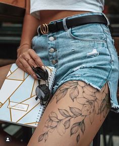 a woman with tattoos on her leg holding a purse