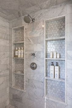 a bathroom with marble walls and shelving in the shower