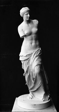 an old photo of a statue of a woman with long hair and no shirt on