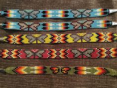 four beaded bracelets are lined up on a brown tablecloth with silverware in them