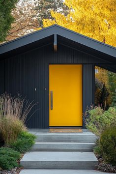 a yellow door sits in front of a black building with steps leading up to it