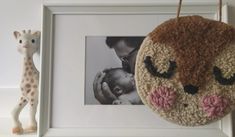 a stuffed animal hanging from the side of a frame next to a baby's head