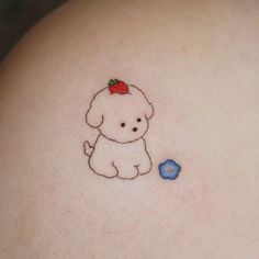 a small dog with a strawberry on it's head sitting next to a blue flower