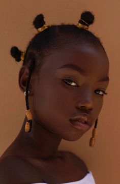 a woman with large earrings on her head and an afro hairstyle is looking at the camera