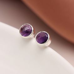 A pair of minimalistic sterling silver February birthstone stud earrings with natural purple amethyst gemstones make the perfect gift for wearers of all ages. Not to be found anywhere on the high street, our beautiful February birthstone studs are crafted from the finest sterling silver. Featuring gorgeous round purple Amethyst gemstones set in a beautiful silver setting, these dainty silver February birthstone earrings feature a classic butterfly and post fastening and are suitable for almost any age.  Our birthstone jewellery can be customised to match the recipient's birthstone or favourite colour or simply to represent their children or family members. Make your earrings even more special by choosing one of our beautiful card inserts, set inside the lid of a high-quality gift box. Add Purple Gemstone Earrings For Everyday Wear, Everyday Purple Gemstone Earrings, Everyday Purple Amethyst Earrings, Amethyst Studs, Birthstone Earrings, February Birthstone, Round Stud Earrings, Birthstone Earring, Amethyst Earrings