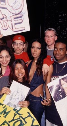 a group of people holding up signs and posing for the camera