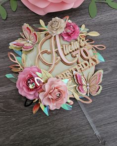 a close up of a cake with flowers and butterflies on it, next to some paper flowers