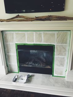 a fireplace with a tv above it and some green tape on the mantels