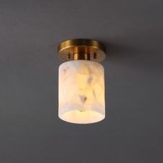 a close up of a light fixture on a wall in a room with grey walls