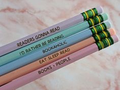 four pencils with writing on them sitting next to each other in front of a marble background