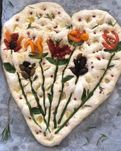 a heart shaped pizza with toppings on it